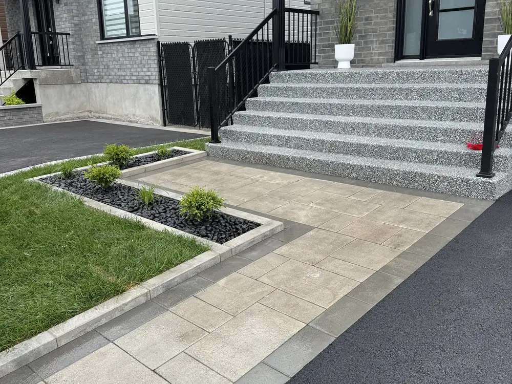 Allée en pavé uni menant aux marches d'une résidence, plates-bandes bordées