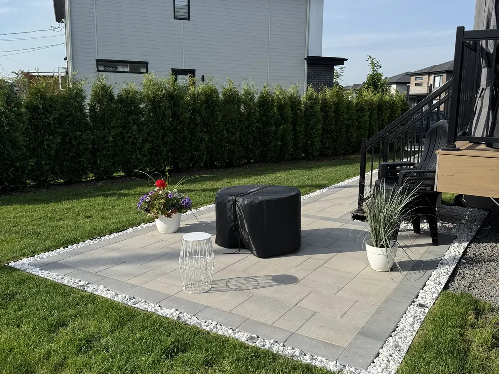 Patio arrière en dalles de béton avec bordure de pierre blanche