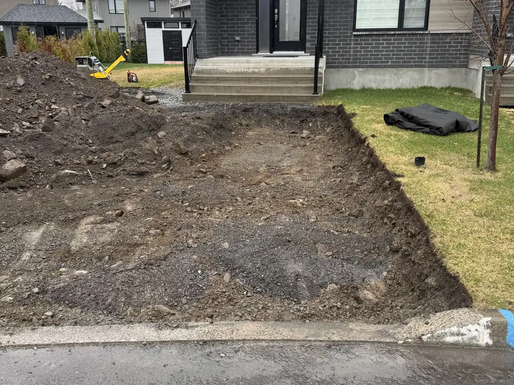 Terrain excavé devant une résidence avant la pose de l'entrée