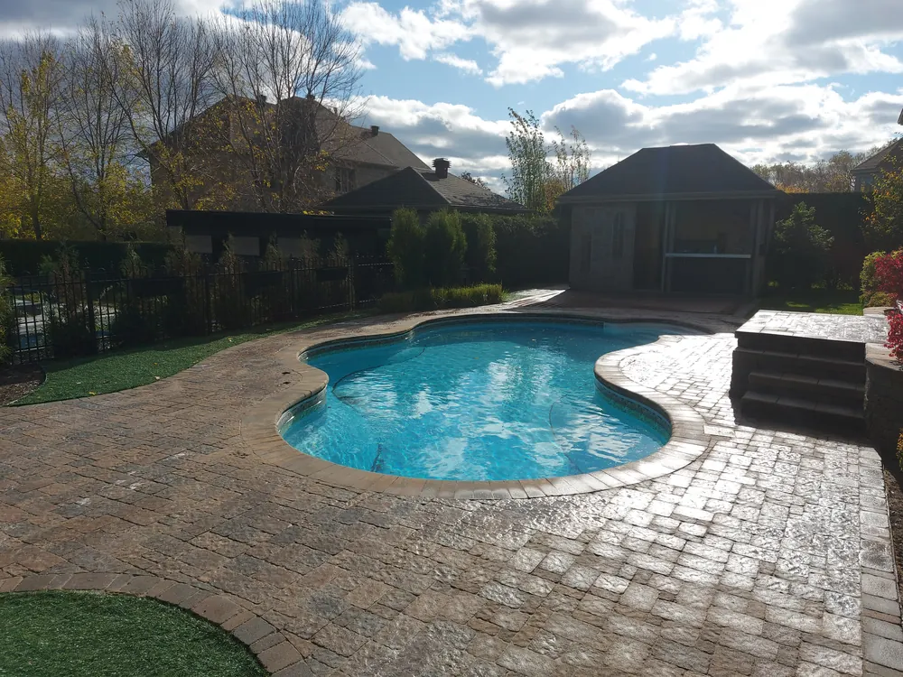 Terrasse en pavé uni autour d'une piscine creusée